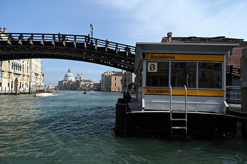 Venice, Italy, march 12, 2024 : Vaporetto stop at Accademia station on the Grand Canal with the Academy Bridge in the background