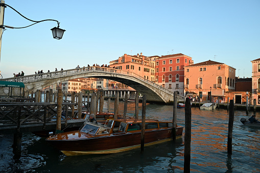 Venice, Italy, march 12, 2024 : Taxi boat on the Grand Canal with the Degli Scalzi bridge in the background at the end of the day