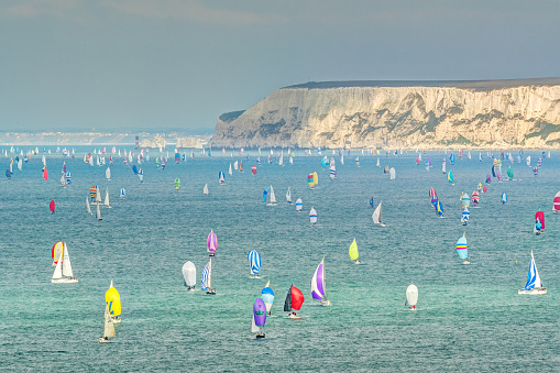 The round the island race is a world famous event that takes place during the summer on the Isle of Wight in the UK. \nHere we can see the 2nd leg  of the race between the Needles and St Catherine's point as the competitors race downwind, utilising their colourful spinnakers.