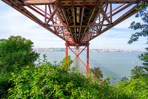 view from below the metallic structure platform of the 25 de Abril bridge from the city of Almada.