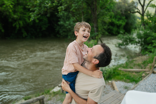 Portrait of a single father spending some quality time with his boy outdoors, by the river