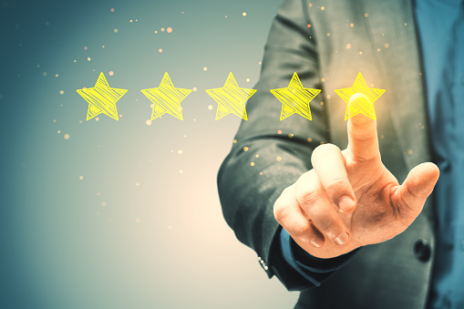 Close up of businessman hand pointing at 5 star rating on blurry background. Customer service and excellent feedback concept