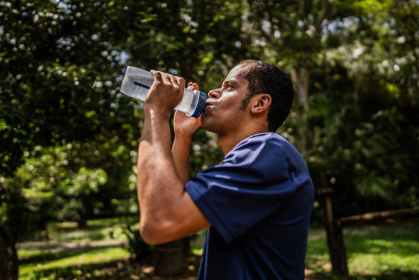 istock Visually impaired man drinking water in public park 2114954480