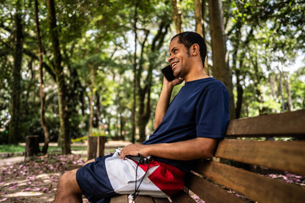 istock Visually impaired man talking on mobile phone at a public park 2114954489