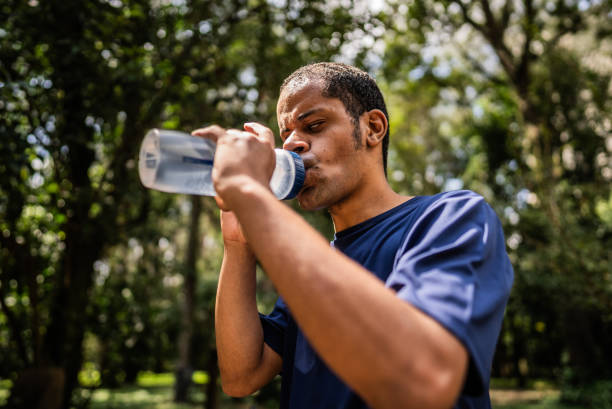 istock Visually impaired man drinking water in public park 2114954494