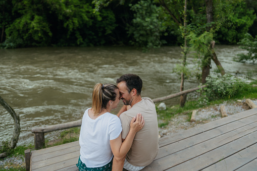 Photo of a loving couple, who enjoy each other's company,  on summer afternoon by the river