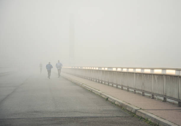 joggeurs dans le brouillard - distance running jogging running fog photos et images de collection