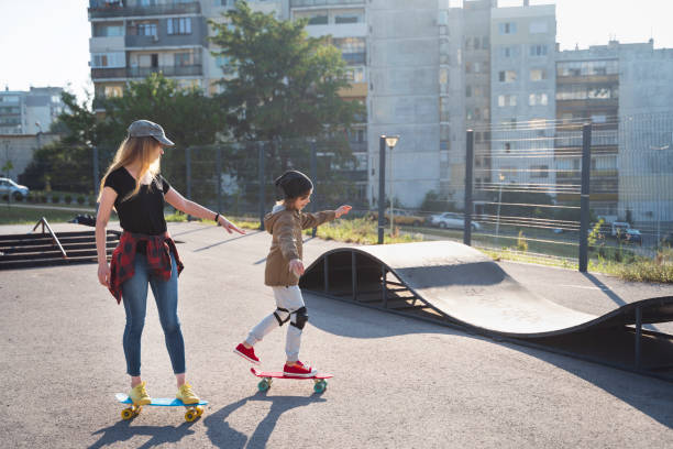 istock Mother and son having skateboarding training in skateboard park 2114984306
