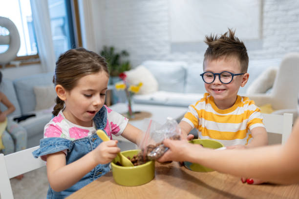 istock Caucasian brother and sister having cereal for breakfast 2114993839