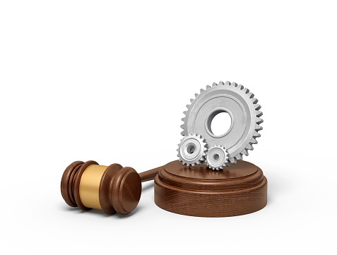 3d rendering of one big and two small light-grey gear wheels on sounding block with gavel lying beside. Court system. Judicial service. Standing trial.