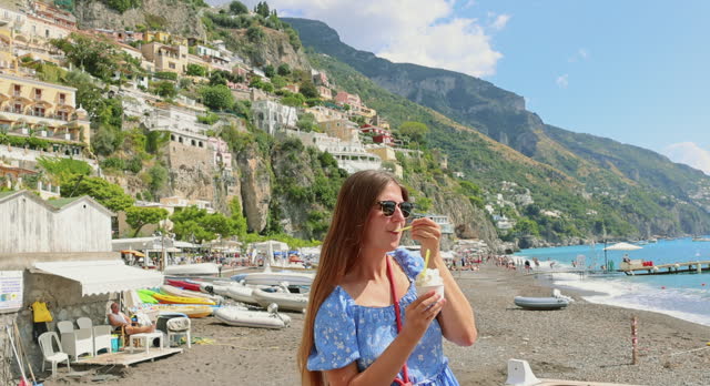 Woman Eating Lemon Gelato with Background view of Amalfi Coast of Italy