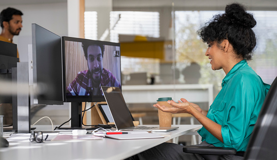 Mid adult latin woman chatting in video call online meeting on computer in her office. Business and Career concept.