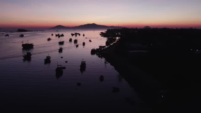 Aerial video above fishing boats in Vietnam Hoi An River, in the evening