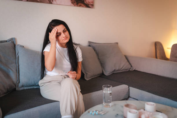 istock Young woman suffering with a headache at home 2115068268