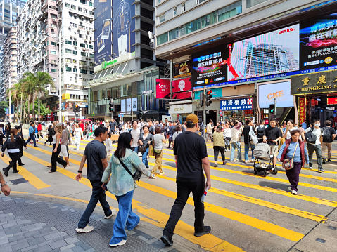 Crowd crossing Nathan road in the busy Tsim Sha Tsui district, Kowloon, Hong Kong,