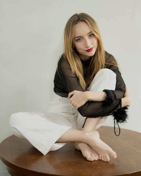 istock Young Blond Woman in Bright Red Lipstick Poses in Studio Setting 2115078192