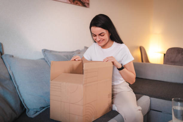 istock Young woman opening her package she ordered online 2115086316