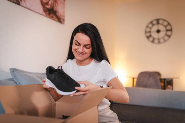 istock Beautiful young woman unpacking a package she ordered online 2115091122