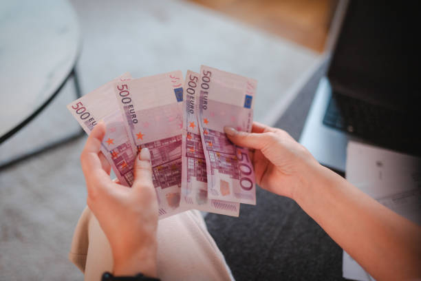 istock Close-up of hands counting money 2115094847