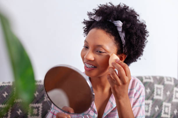 istock beautiful black woman finishing her daily makeup routine 2115105484