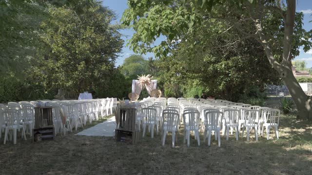 Slow motion panning shot of an exterior wedding reception seating area