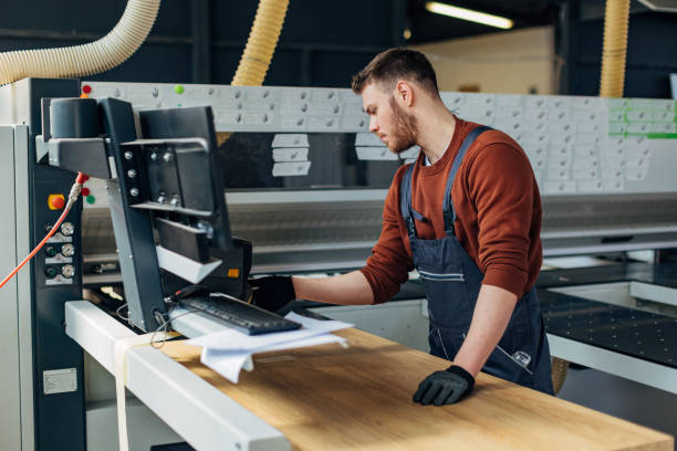 istock A worker uses an automatic machine for cutting wood while making furniture 2115122479