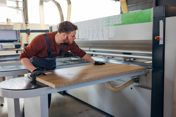 istock A worker makes furniture in the workshop using an industrial machine for automatic cutting of wood and chipboard 2115123042
