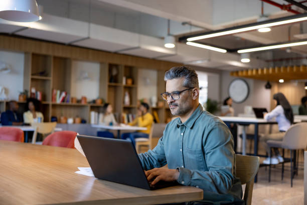 istock Successful businessman working on his laptop at a coworking office 2115127948
