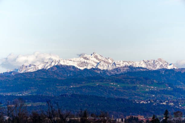 Scenic landscape with Glatt Valley, woodland, hills, snow covered mountains and Säntis peak seen from Swiss City of Zürich. Photo taken March 26th, 2024, Zurich, Switzerland.