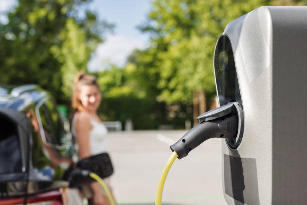 istock Young woman charging electric car 2115139245