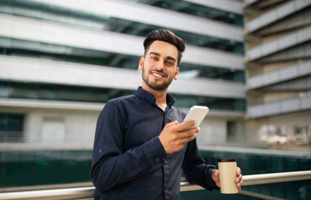 istock Successful arab businessman typing on smartphone near office building 2115142455