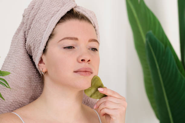 istock Woman performing facial massage with gua sha 2115162949