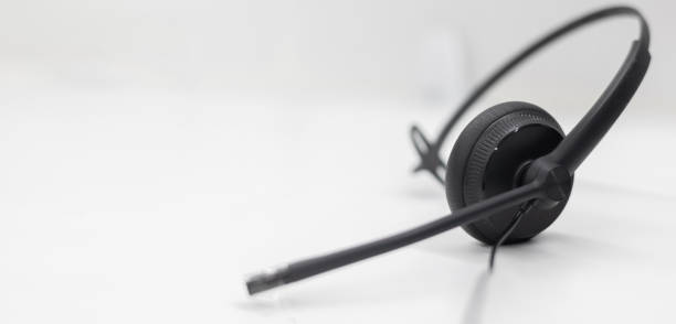 istock close up black headset on the white table background in 24/7 operation room to communicate with provider or response client for call center and hotline service concept 2115184415