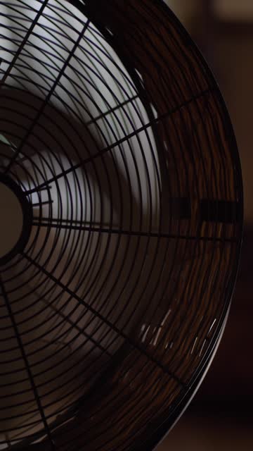 The electric domestic spinning fan in room. Close up, cinematic.