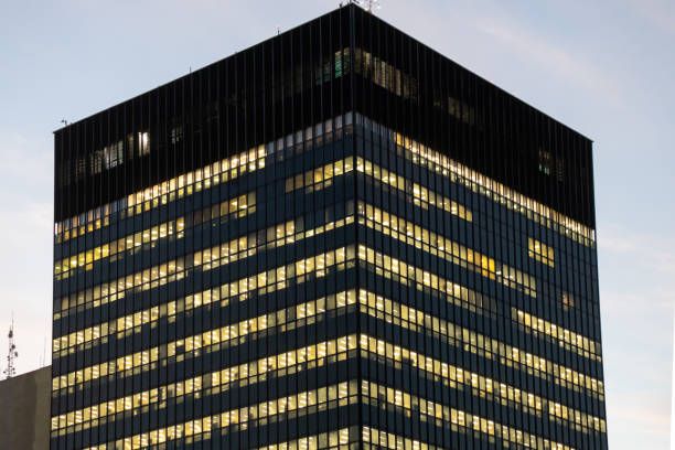 Commercial building at dusk with office lights on.