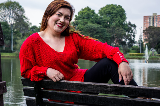 Beautiful young woman posing in a public park