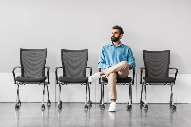 istock Indian man waiting calmly in office with empty chairs 2115225900