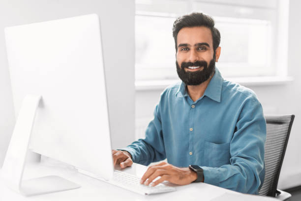 istock Confident indian businessman working at computer in office interior 2115226238