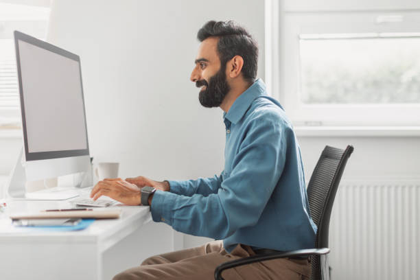 istock Focused indian businessman working on computer in office 2115226467