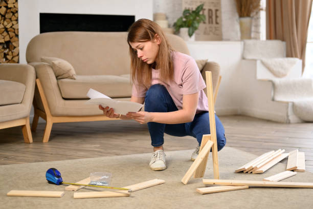 istock woman enthusiastically assembles a rack or shelf according to instructions 2115251331