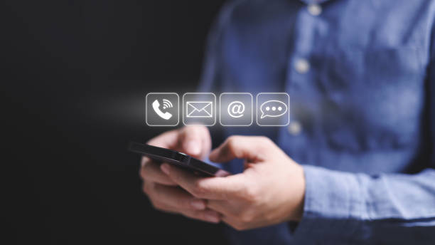 istock A man holding a smartphone and looking at a screen with icons for phone, email, voicemail, and text messaging for contact point. 2115252384