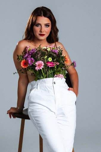Young beautifull Woman covered with flowers, studio shoot