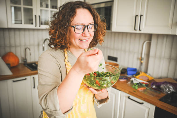 istock Woman eating vegetable salad 2115281646