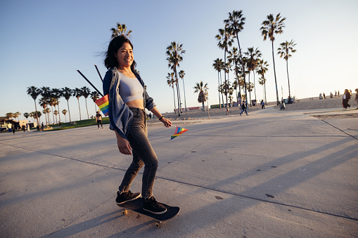 Young woman skating at sunset in Venice Beach, California.