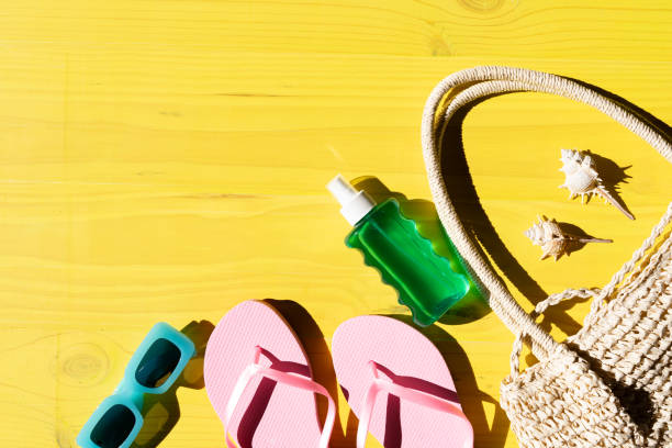 istock Composition created with beach accessories to create summer vacation concept, flip flops, sun lotion, beach bag, sunglasses on yellow wooden boards background 2115336984