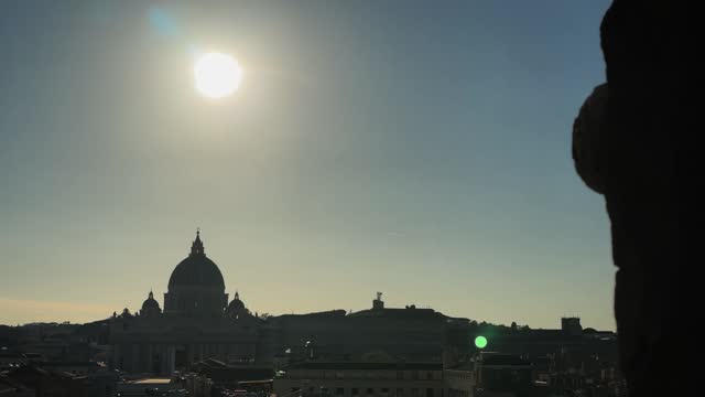 Amazing panoramic Rome skyline cityscape view with dome, roof of St Peter in the Vatican, Rome, surrounded by the rays of the sun at sunset, cinematic establishing shot
