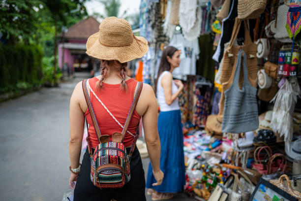 Young, beautiful Asian female tourist shopping at a bazaar on Bali Island.