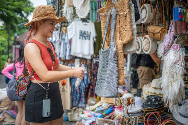 Chic Exploration: A Young, Beautiful Asian Female Tourist Enjoys Street Shopping in Bali's Bustling Bazaar