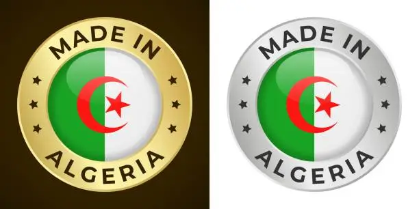 Vector illustration of Made in Algeria - Vector Graphics. Round Golden and Silver Label Badge Emblem Set with Flag of Algeria and Text Made in Algeria. Isolated on White and Dark Backgrounds