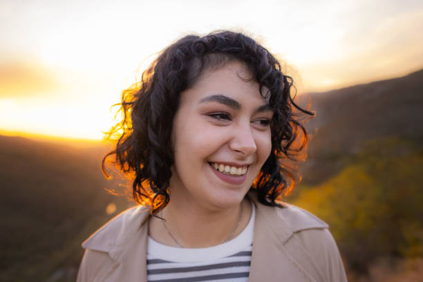 istock Young woman smiling at sunset 2115366204